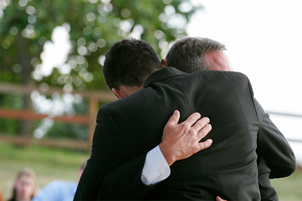 two men in suits hugging